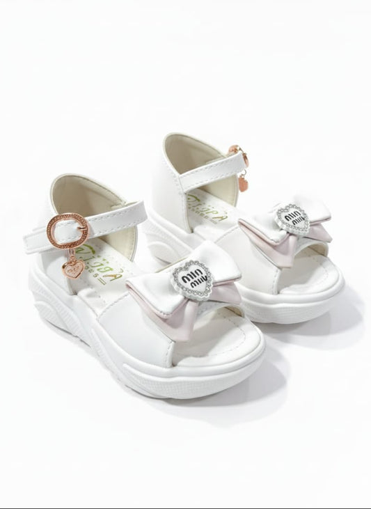 Cloud White Character: White chunky platform sandals jin par shimmery straps aur cute character bow hai.